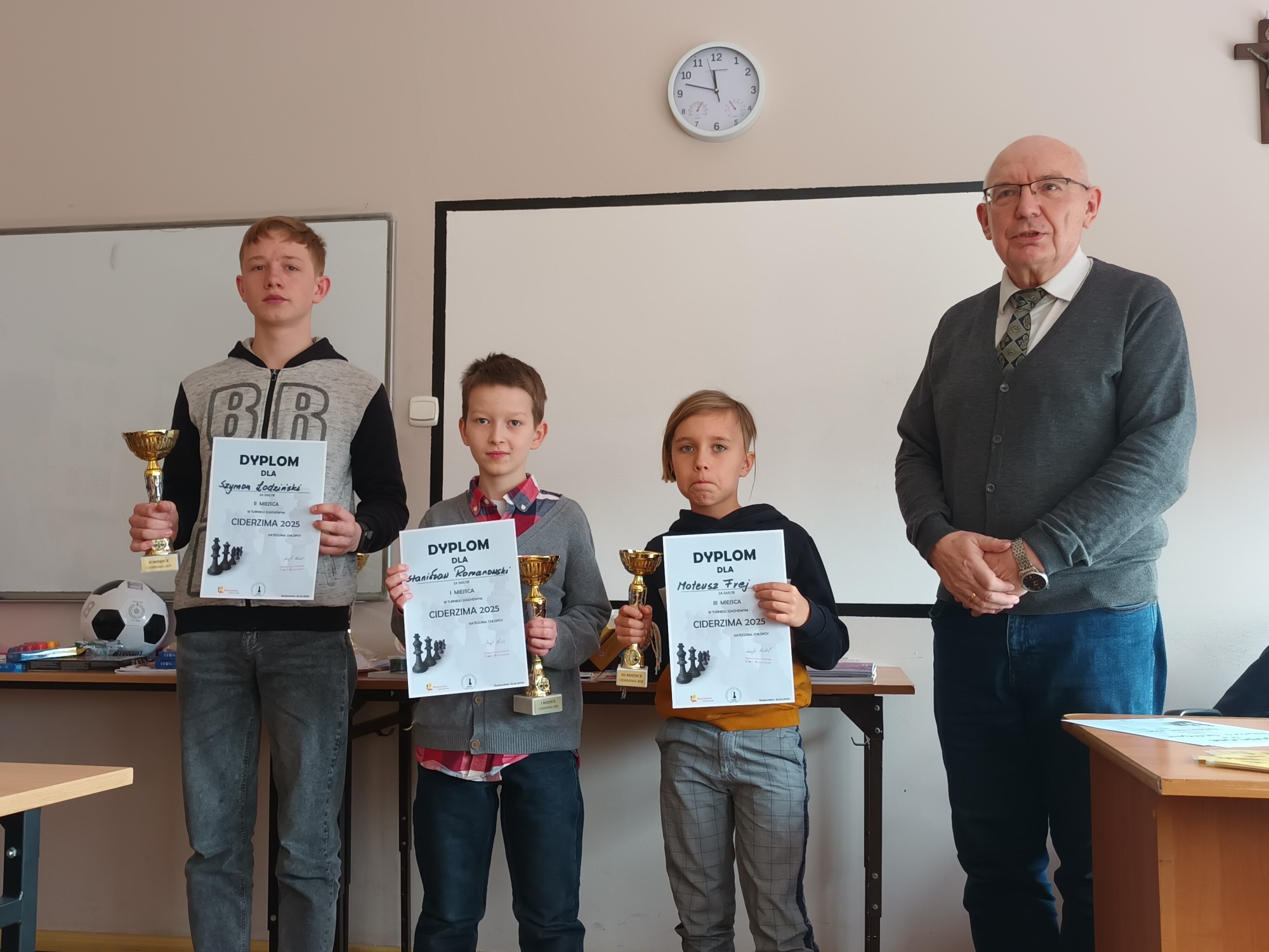 Zwycięzcy turnieju szachowego trzymają dyplomy i puchary