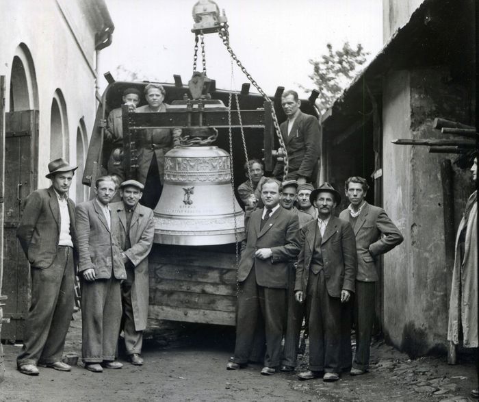 Historyczne zdjęcie przedstawiające pracowników odlewni z nowym dzwonem.