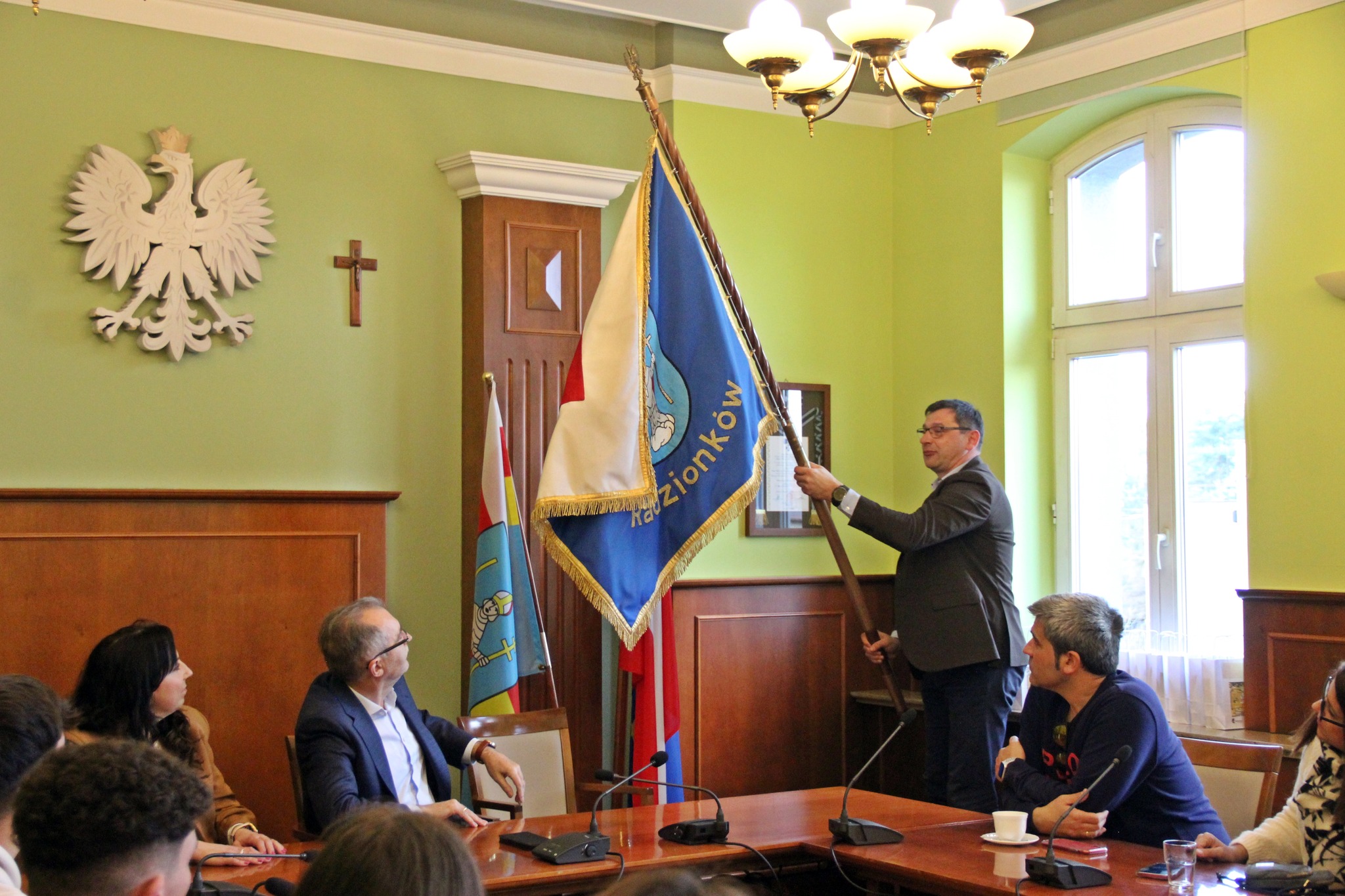 Przedstawiciel Urzędu Miasta pokazuje sztandar miasta Radzionków
