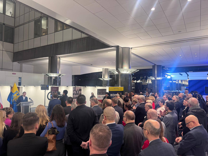 Grupa uczestników wysłuchujących przemówienie w Parlamencie Europejskim