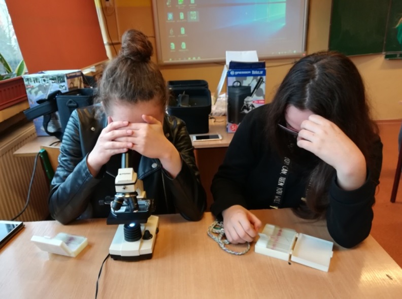 Dziewczyny oglądają coś przez mikroskop